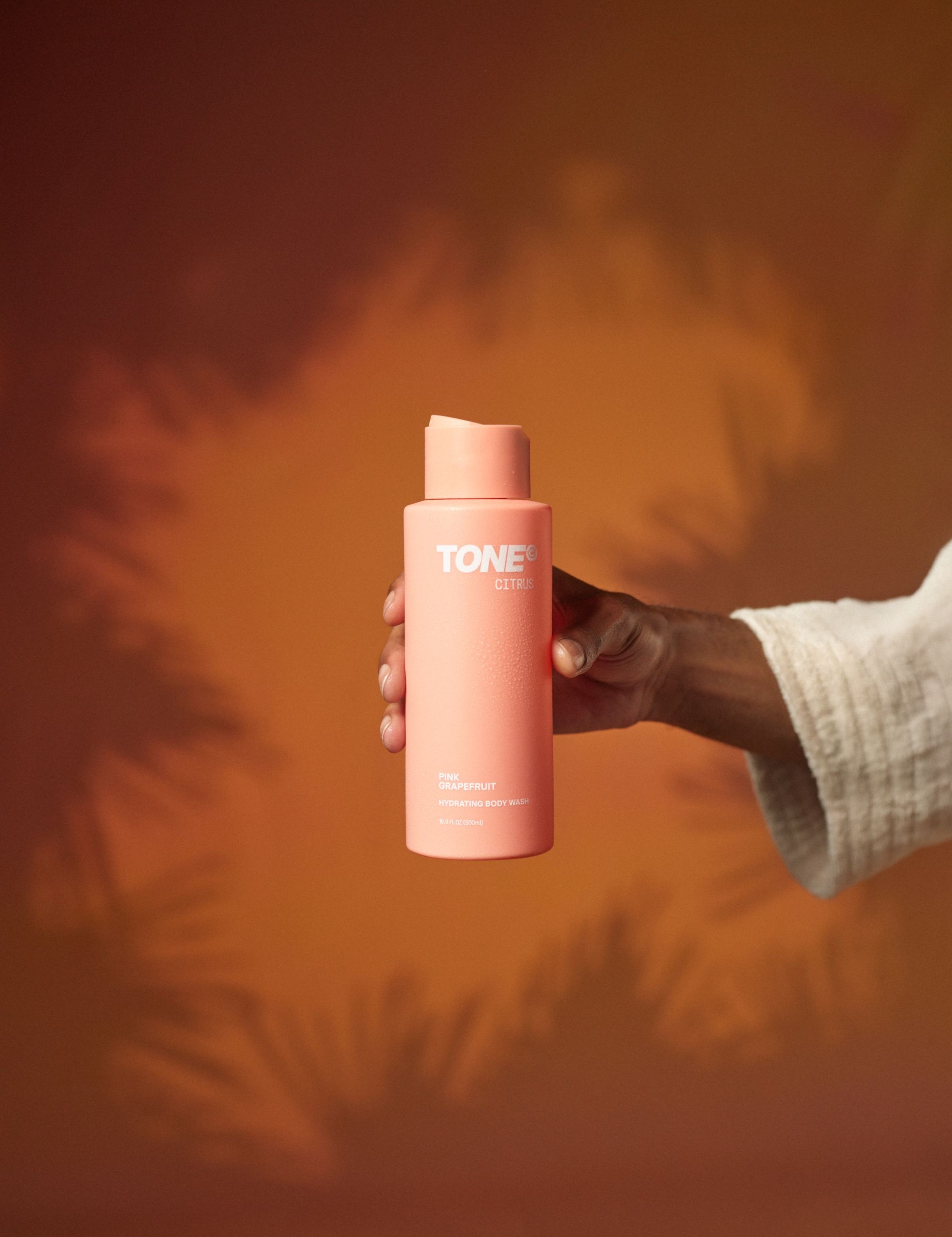 Hand Holding TONE Citrus Pink Grapefruit Hydrating Body Wash
